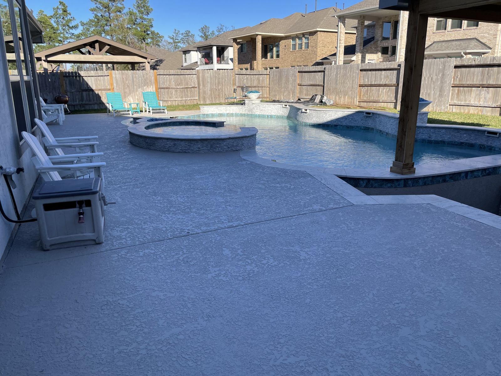 Pool deck and raised spa seen from under a cedar pergola