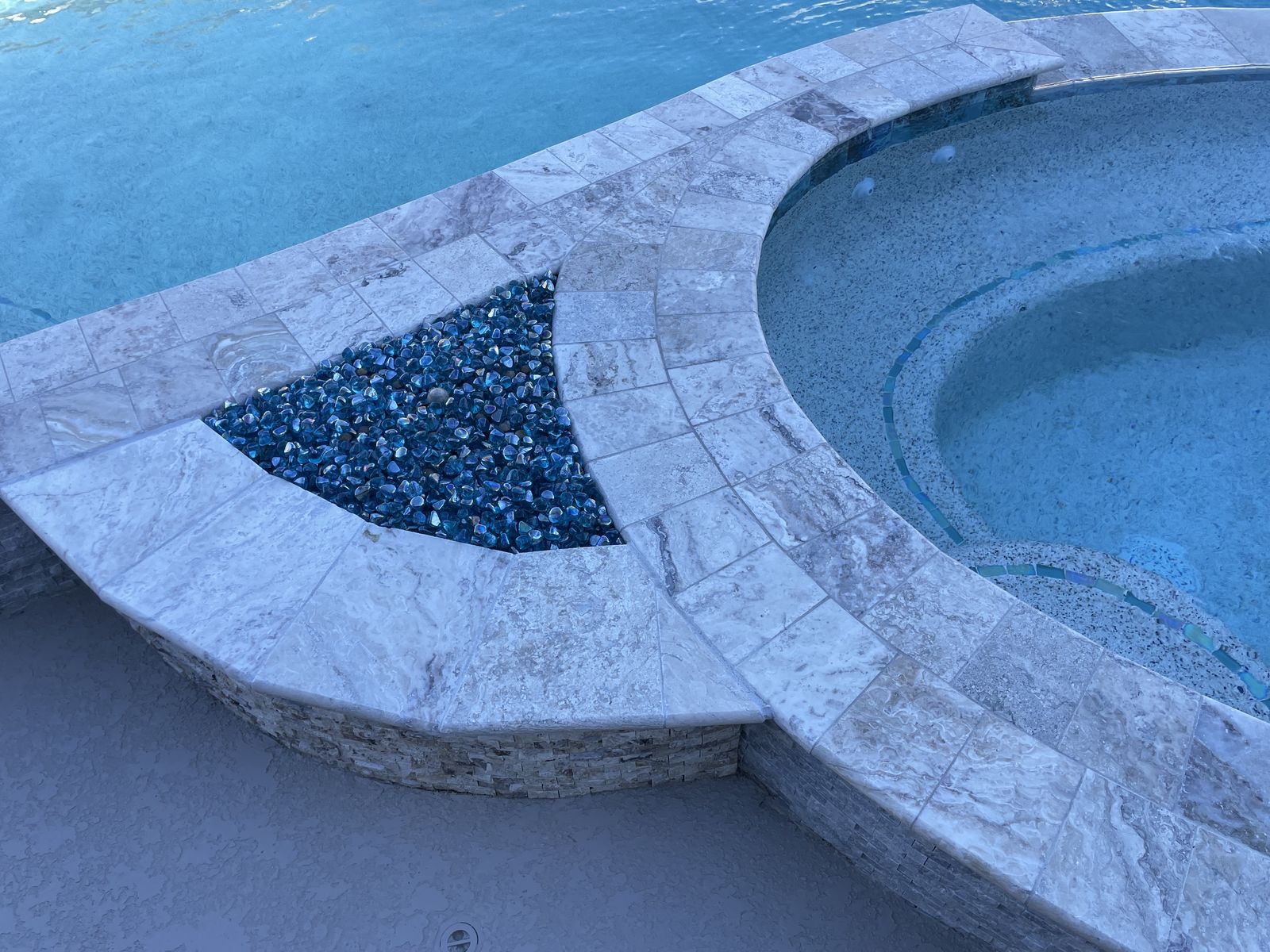 Travertine coping, fire bowl and spa tile detail