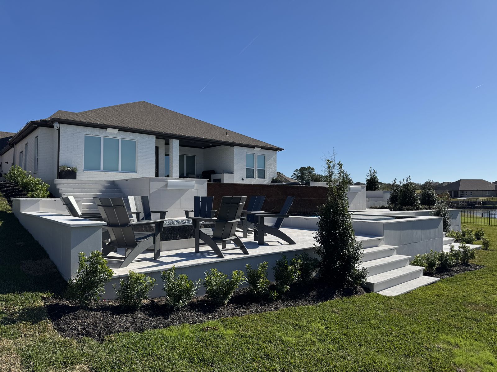 Finished lakefront pool with stone steps, fire pit and lounge deck in Montgomery, TX