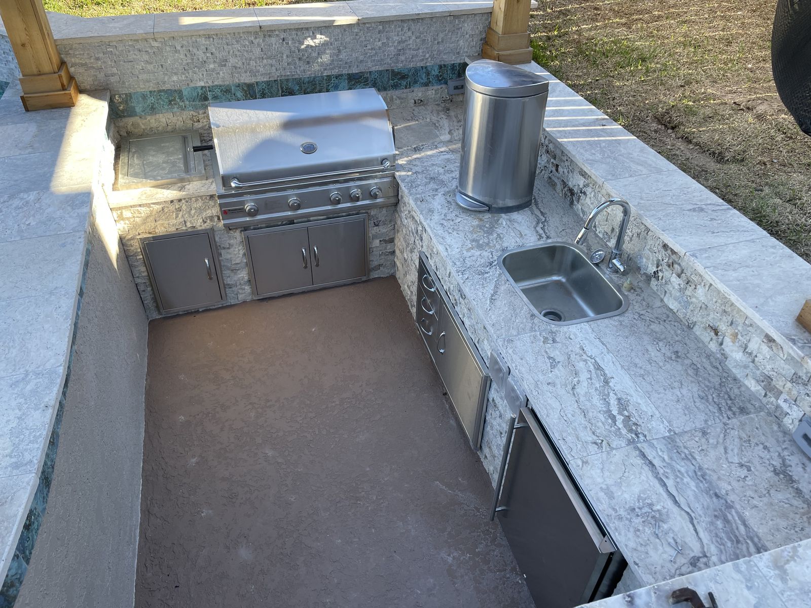 Built-in grill, cabinets and sink in the outdoor kitchen