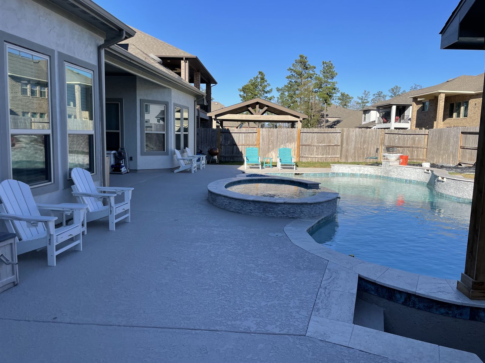 Pool deck with raised spa and Adirondack chairs